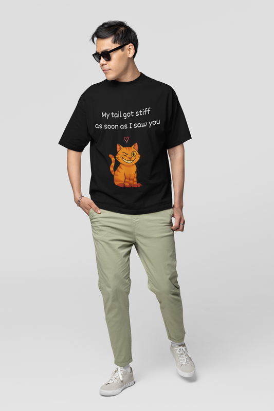 Person wearing a black t-shirt with a cat graphic and text, standing against a white background
