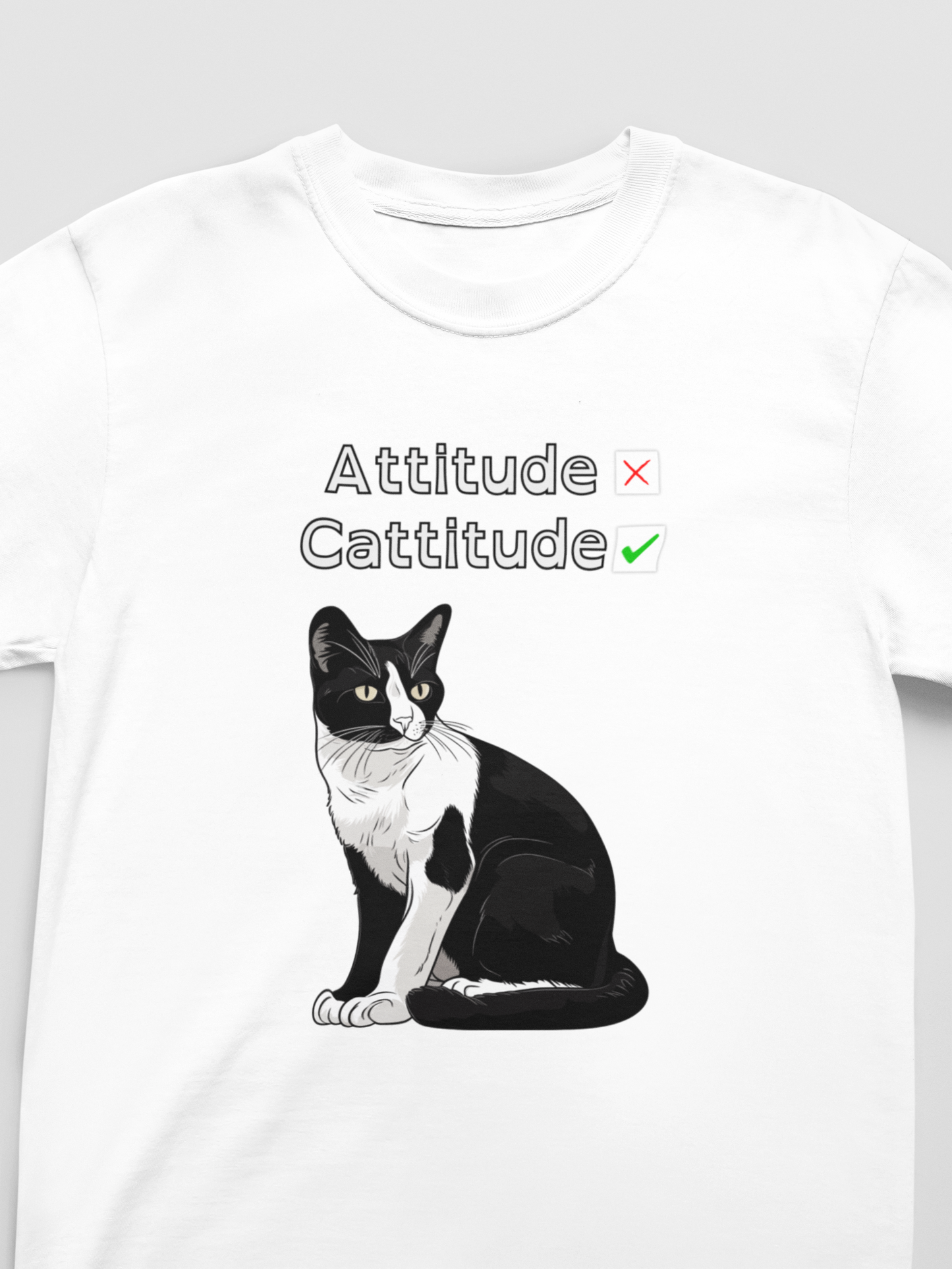 White t-shirt with a black and white cat graphic and text 'Attitude Cattitude' on a gray background
