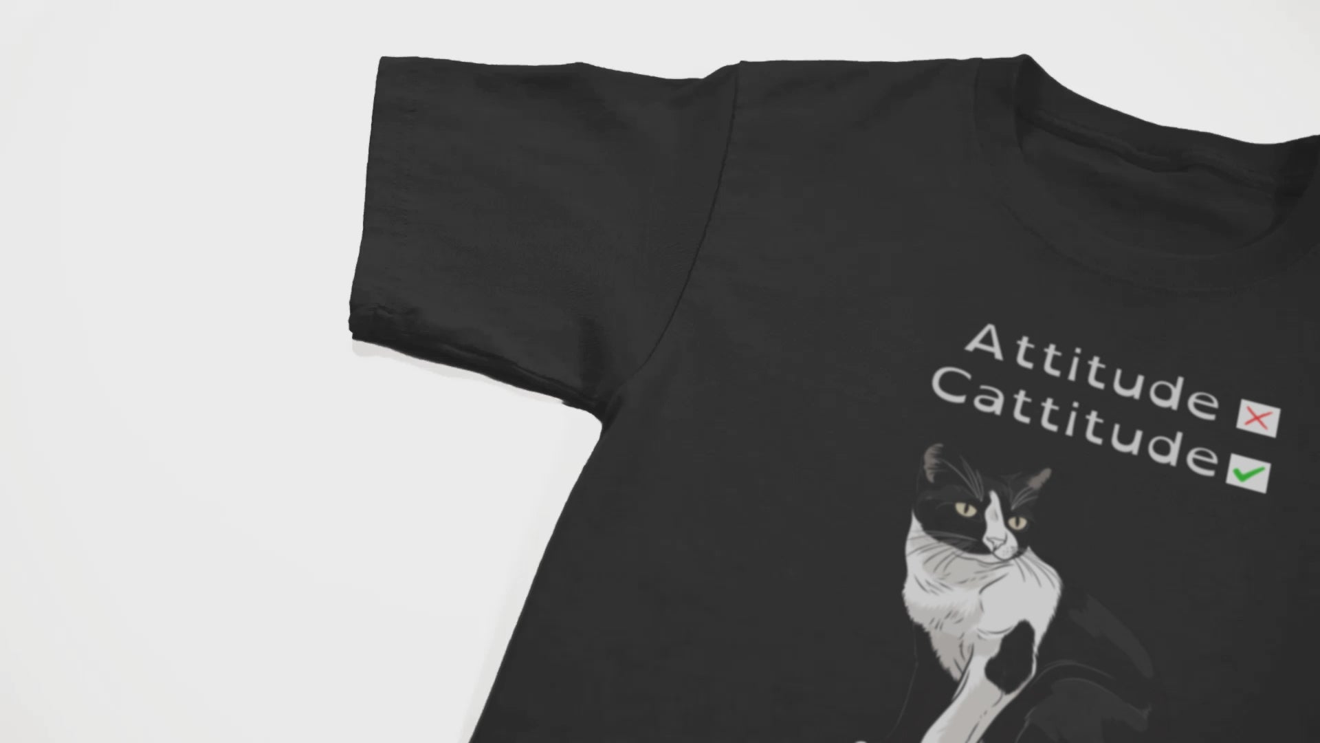 camera pans over a black shirt with a black cat on it and some text